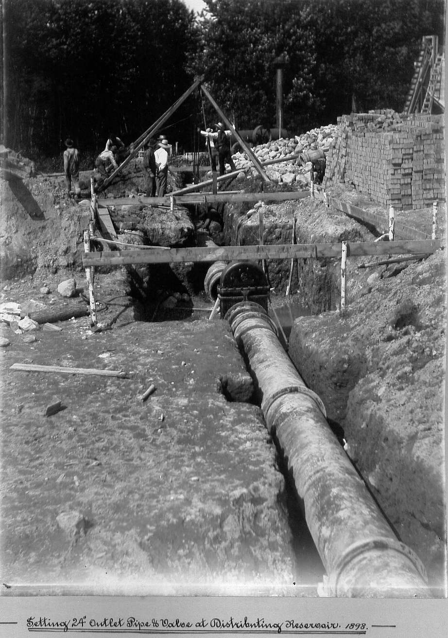 Men connecting 24" pipe and valve